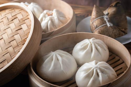 three-steamed-bao-buns-sit-in-a-small-wooden-basket-1400_1768364251.jpeg